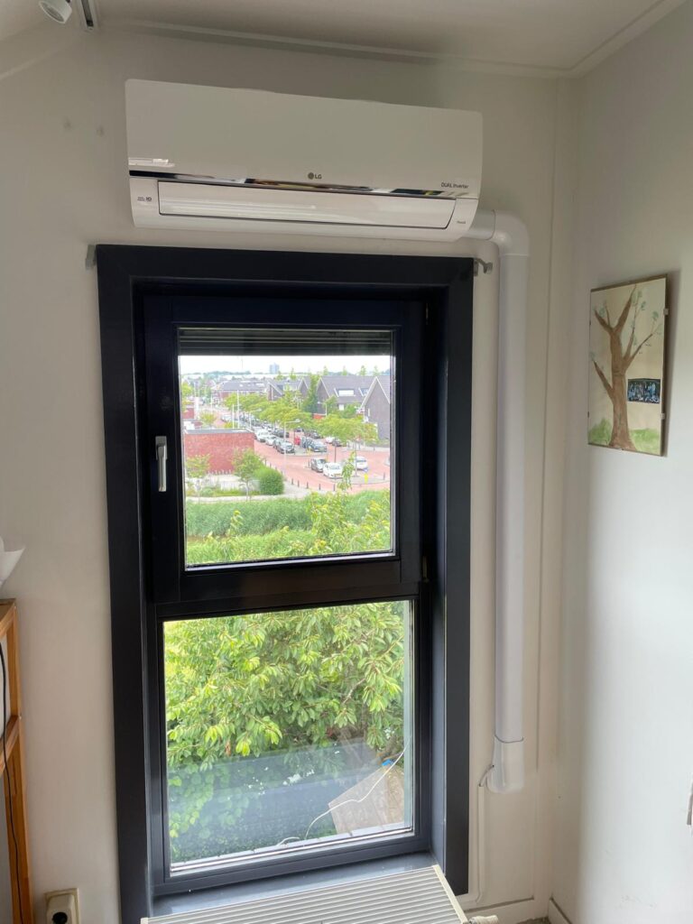 Monteur installeert een airco-buitenunit bij een woning