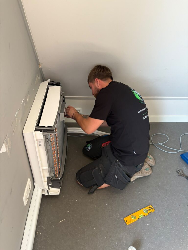 Monteur installeert en sluit een airco-binnenunit aan